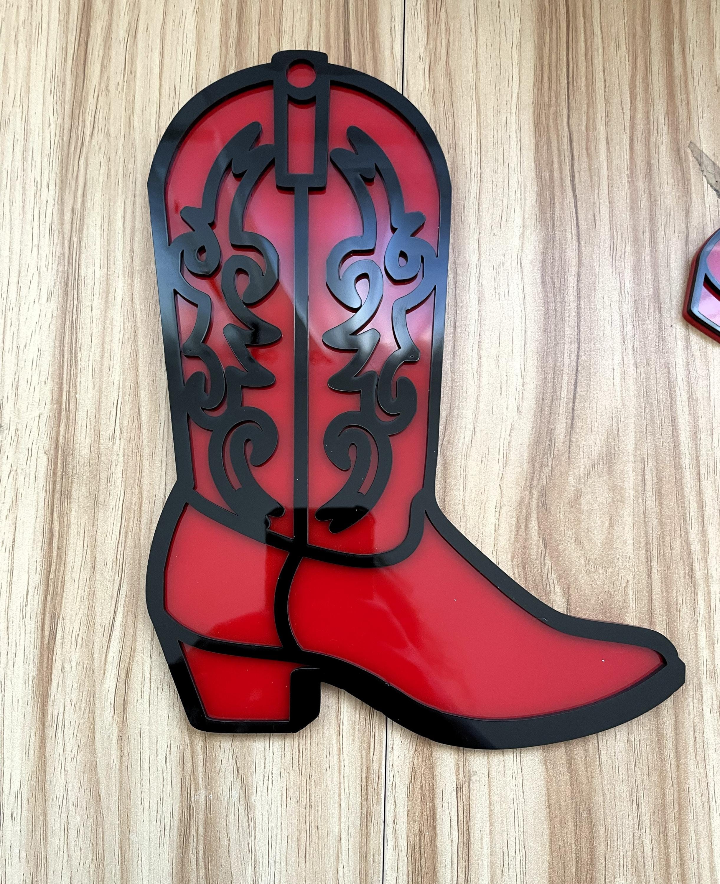 Red cowboy boot with black detailing on a wooden surface
