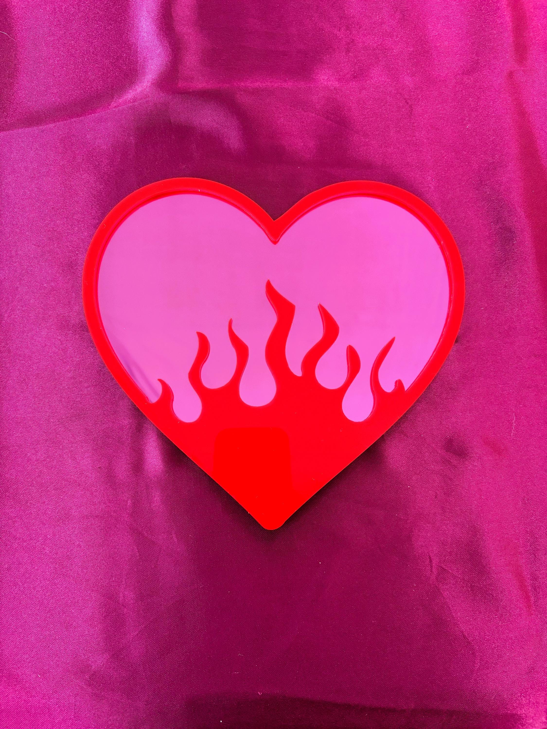 Heart-shaped sticker with flames on a pink background