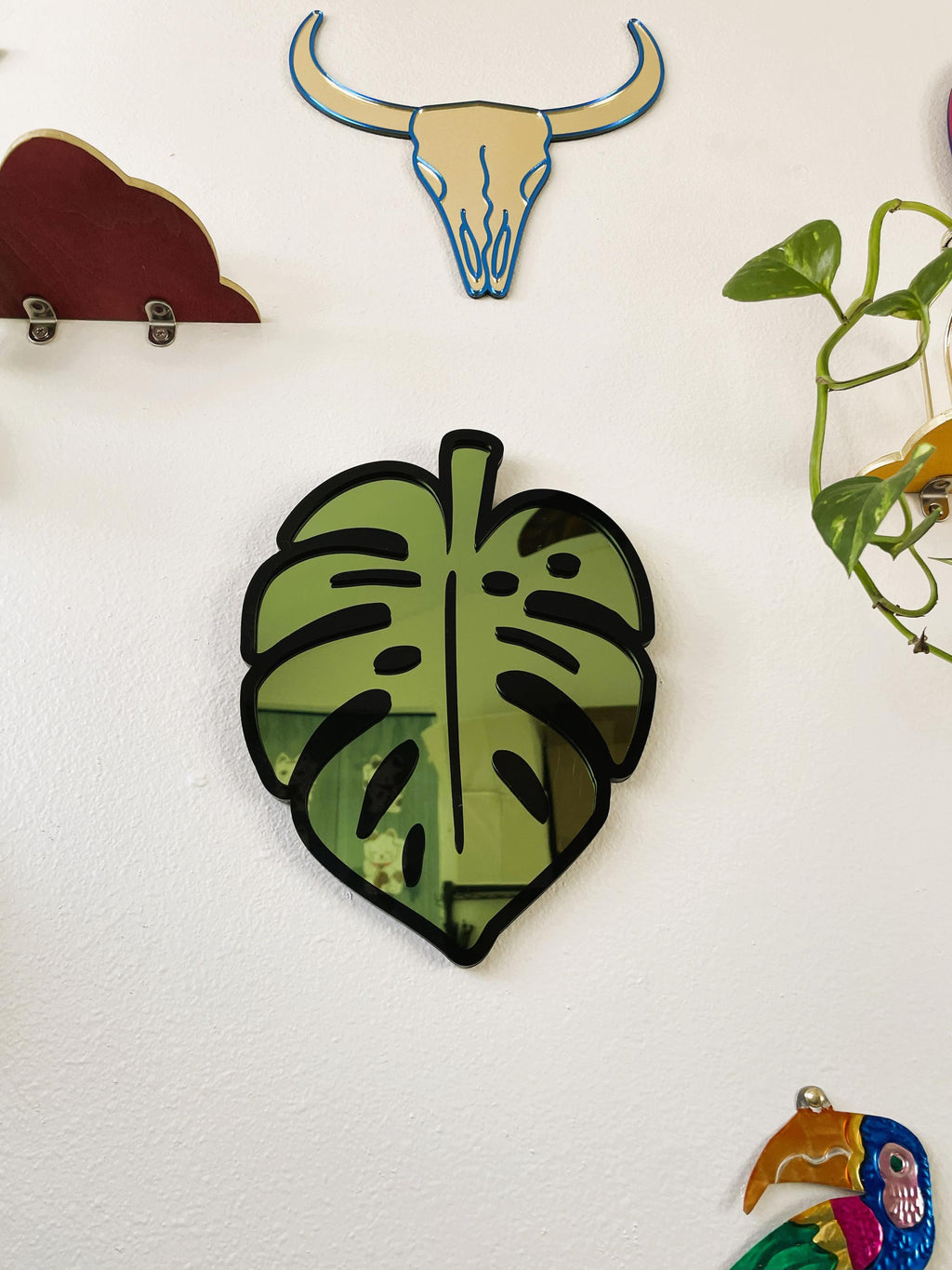 Decorative wall stickers including a green leaf, bull skull, and colorful parrot on a white background.