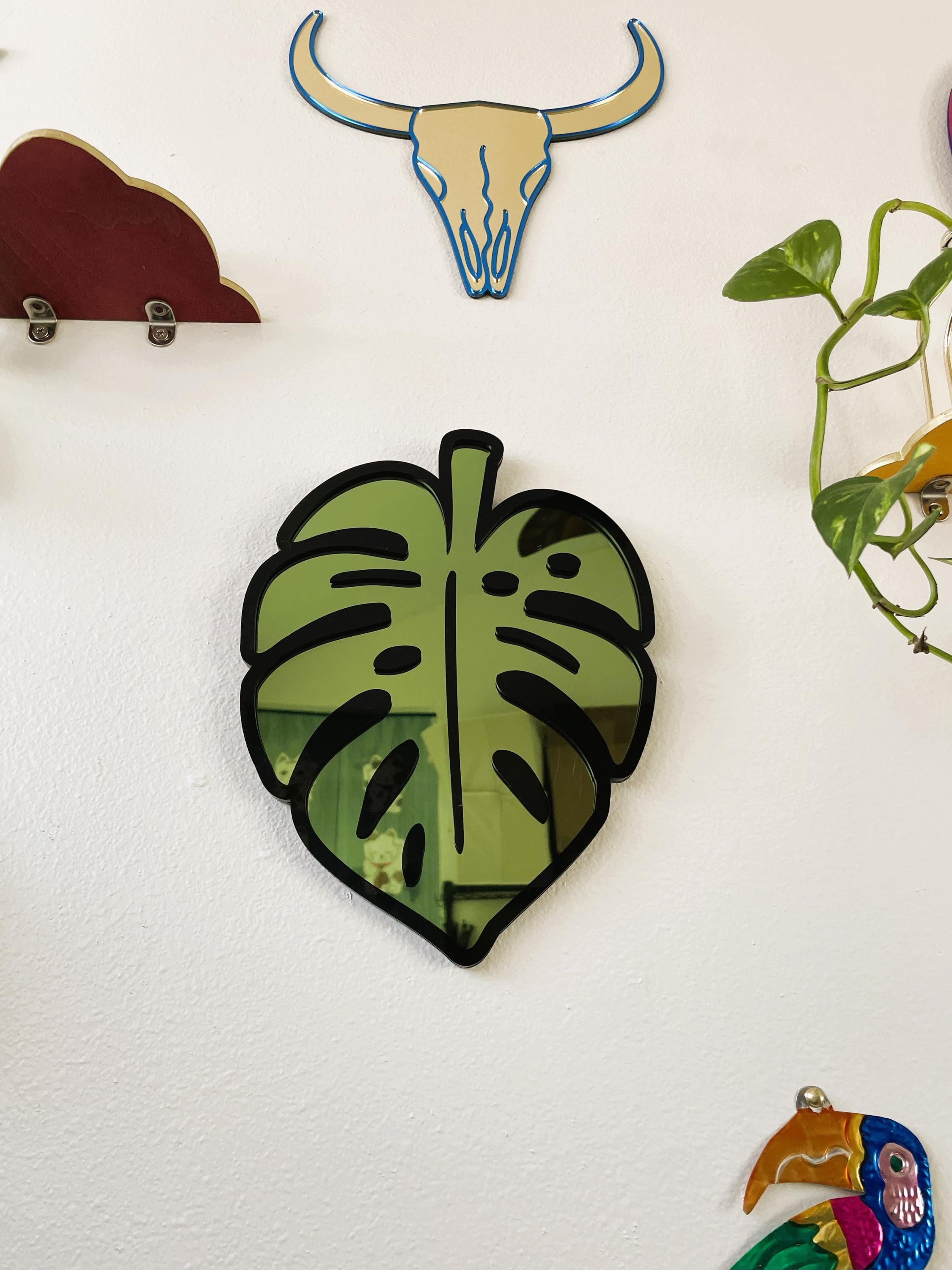 Decorative wall stickers including a green leaf, bull skull, and colorful parrot on a white background.