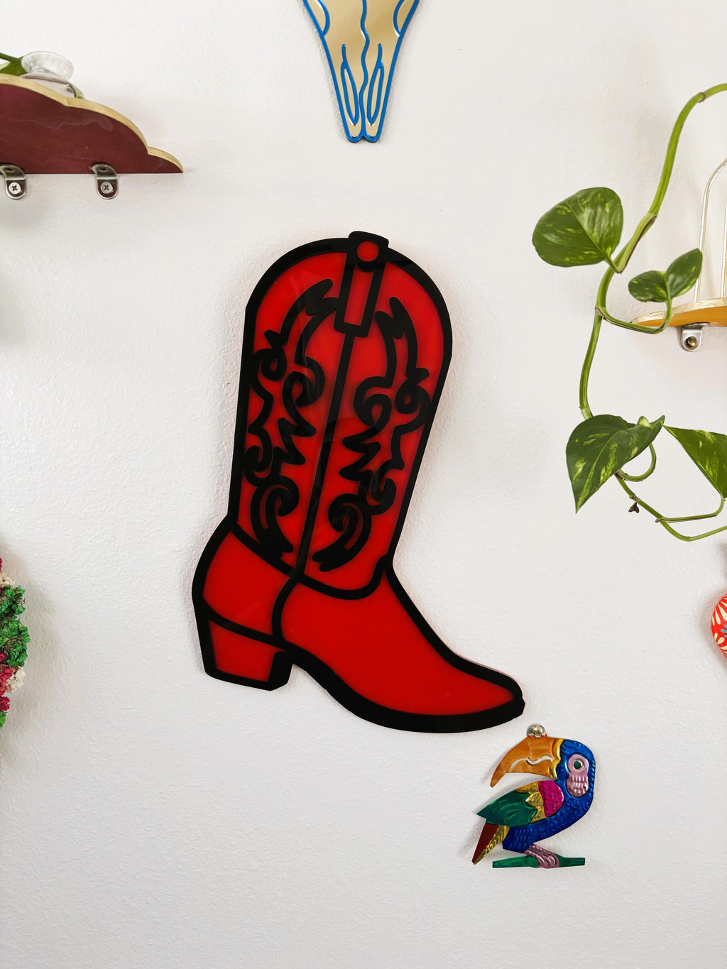 Red cowboy boot-shaped object on a white background with decorative elements.