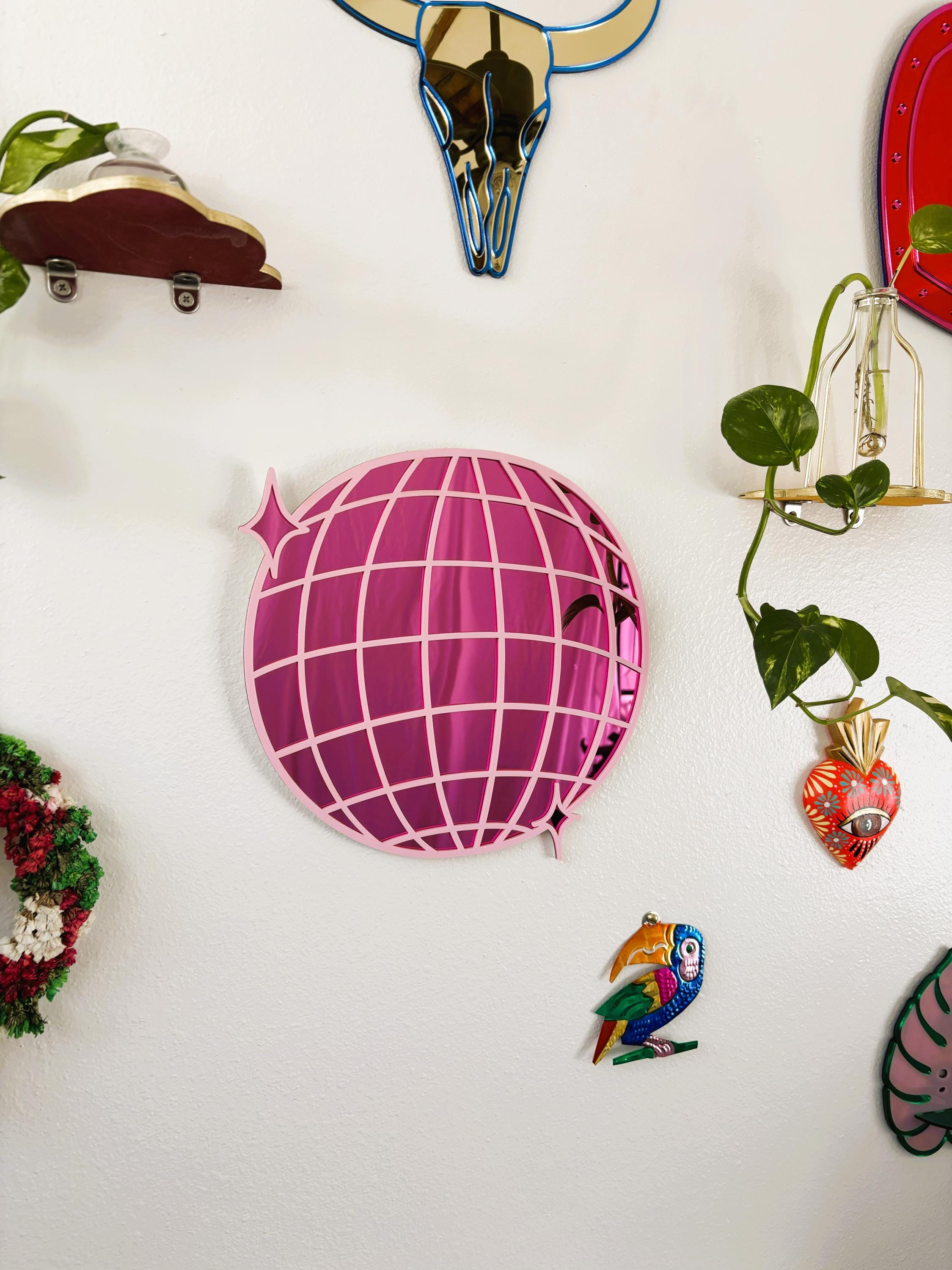 Decorative items including a pink globe with a face, a blue skull, and a red circle on a white wall.