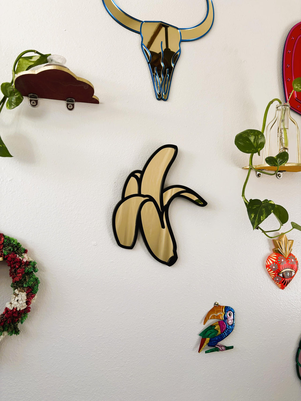 Collection of decorative wall art pieces on a white wall.