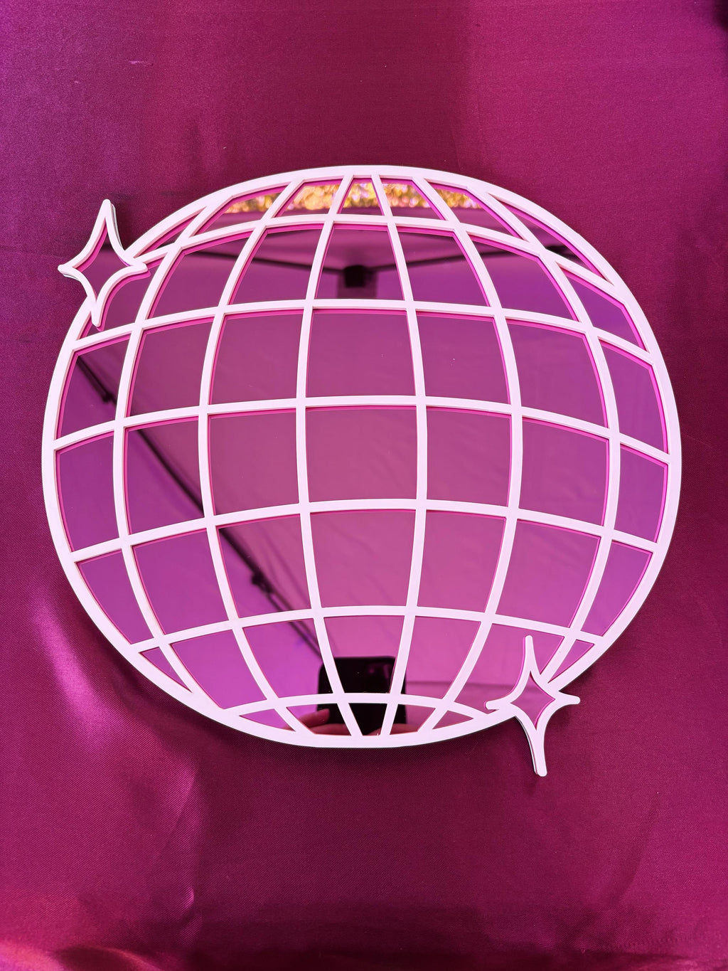 Decorative pink globe with grid pattern on a matching pink background