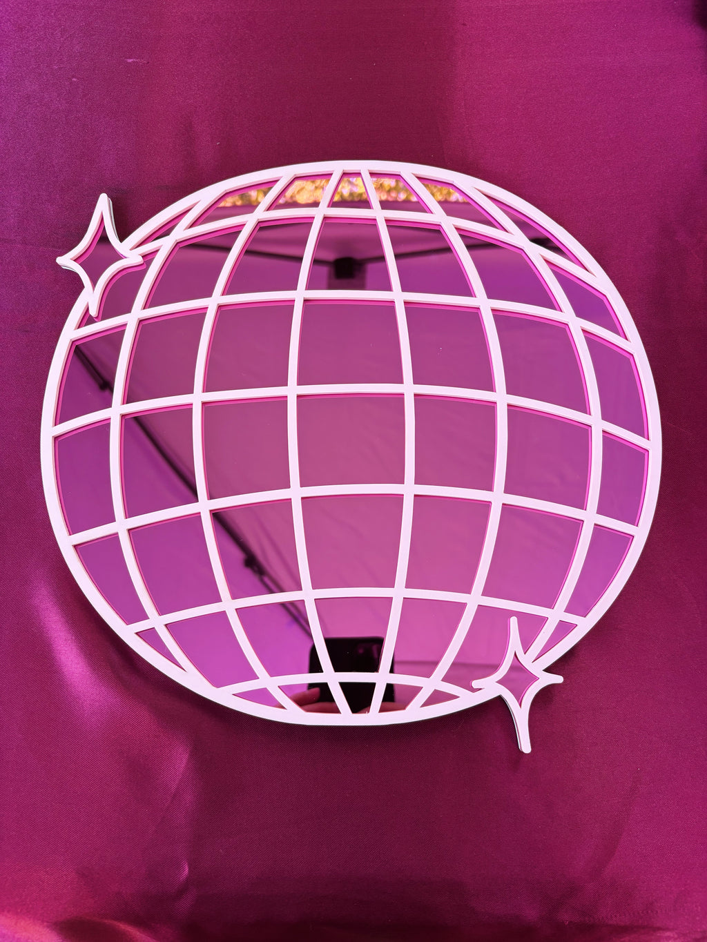 Pink disco ball with grid pattern on a pink background