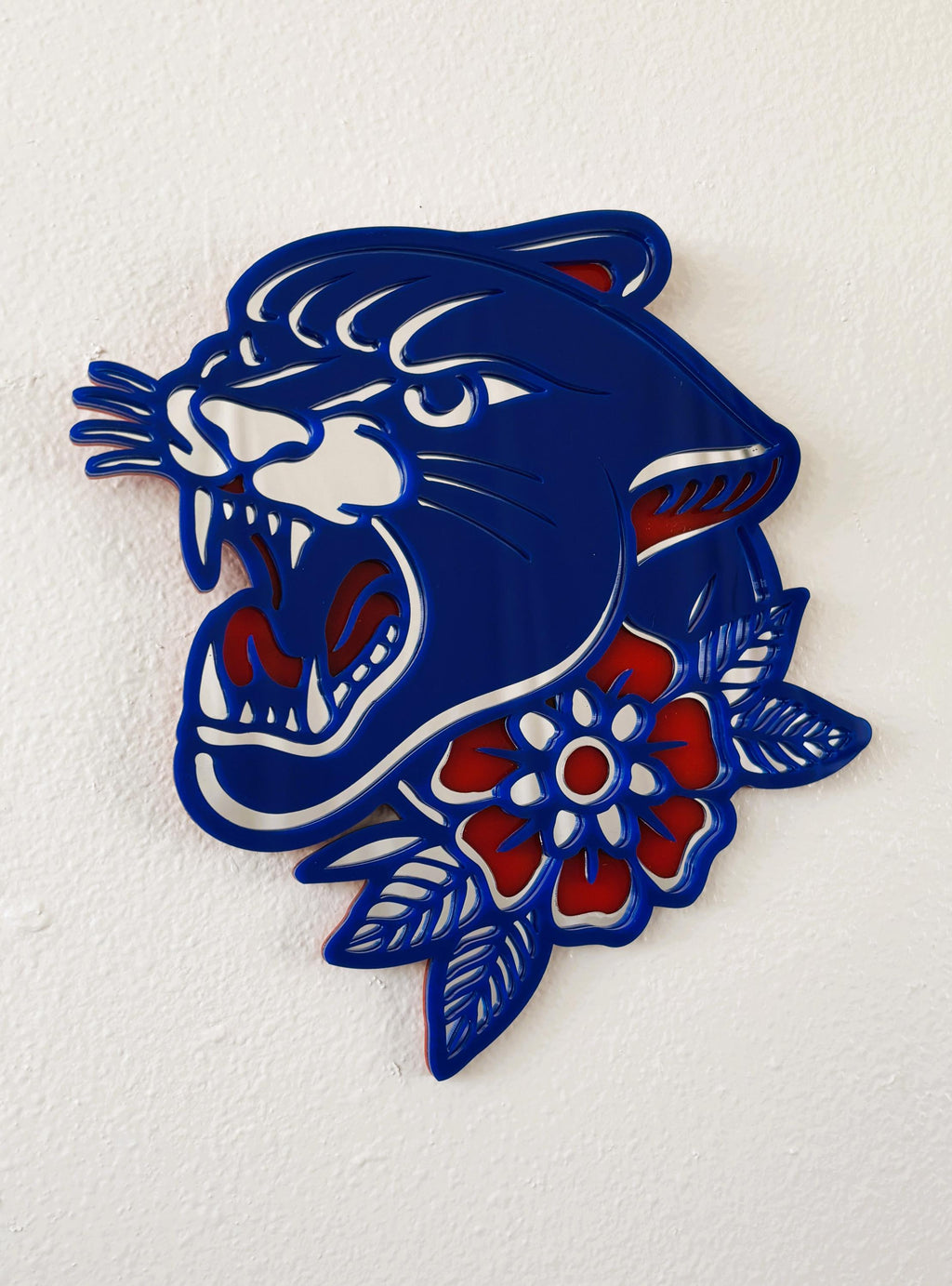 Blue panther head design with red flowers on a white background