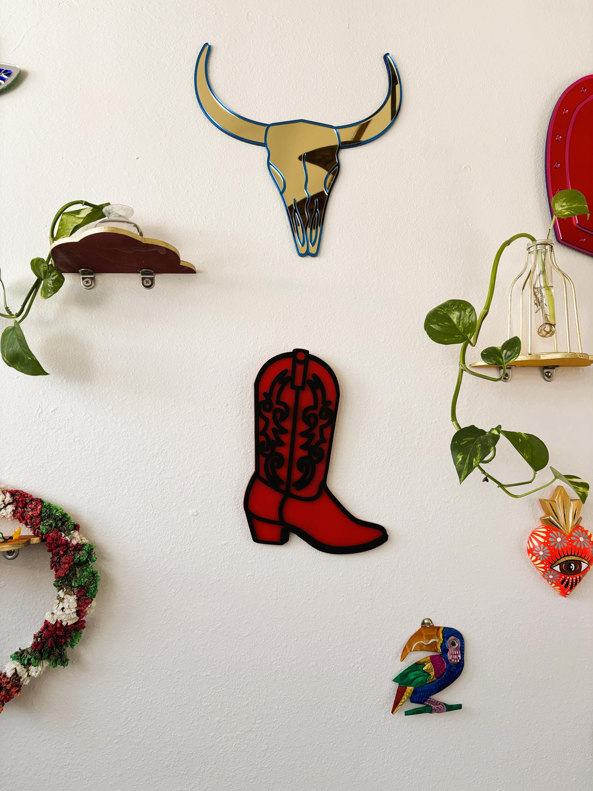 Decorative magnets on a white board including a red cowboy boot, bull skull, and other shapes.