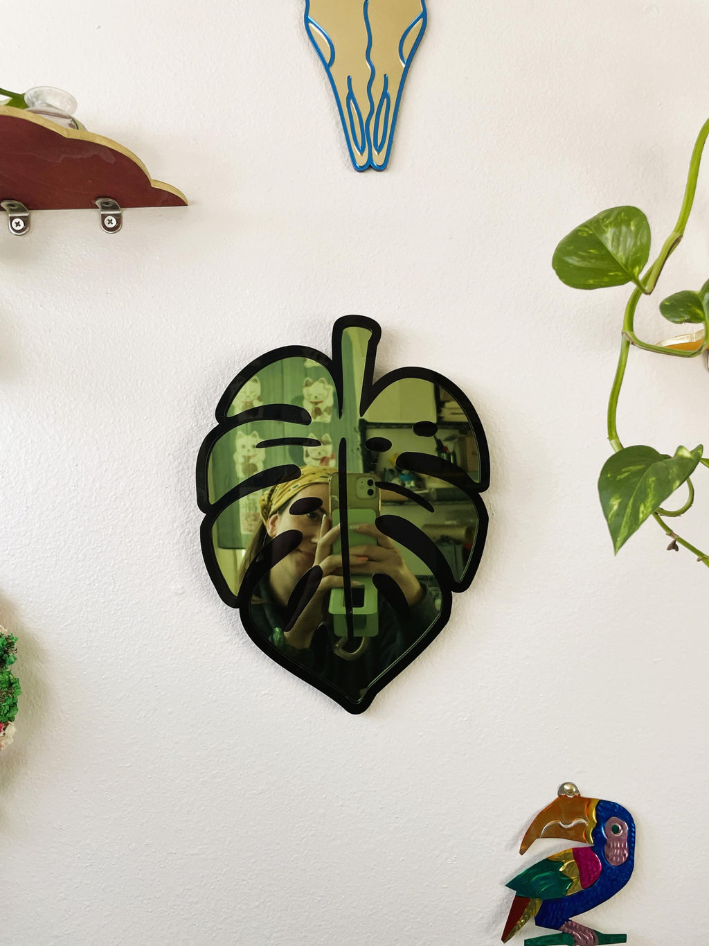 Decorative leaf-shaped object on a white surface with other decorative items.