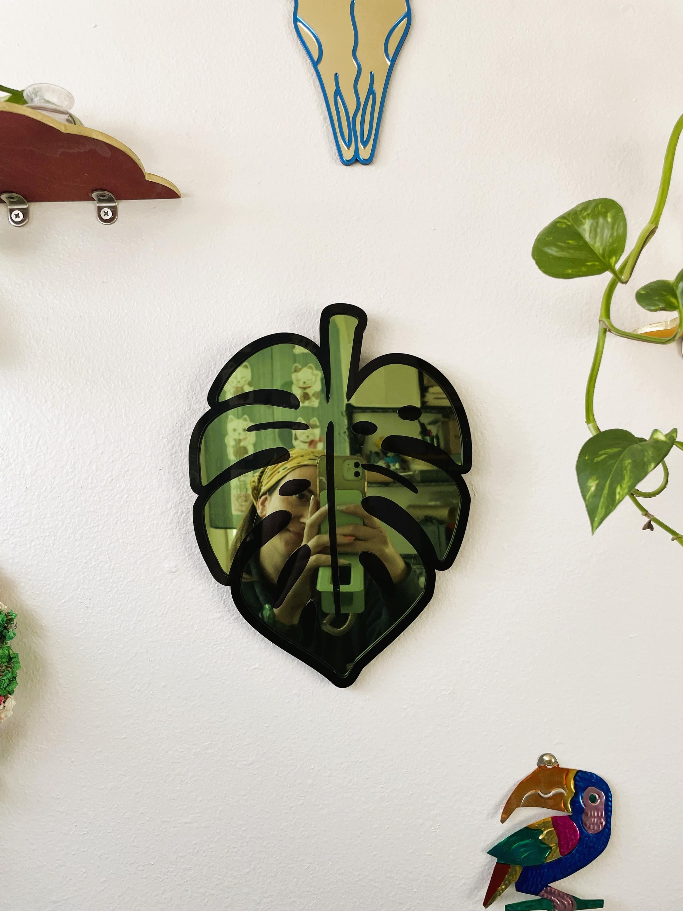 Decorative leaf-shaped object on a white surface with other decorative items.