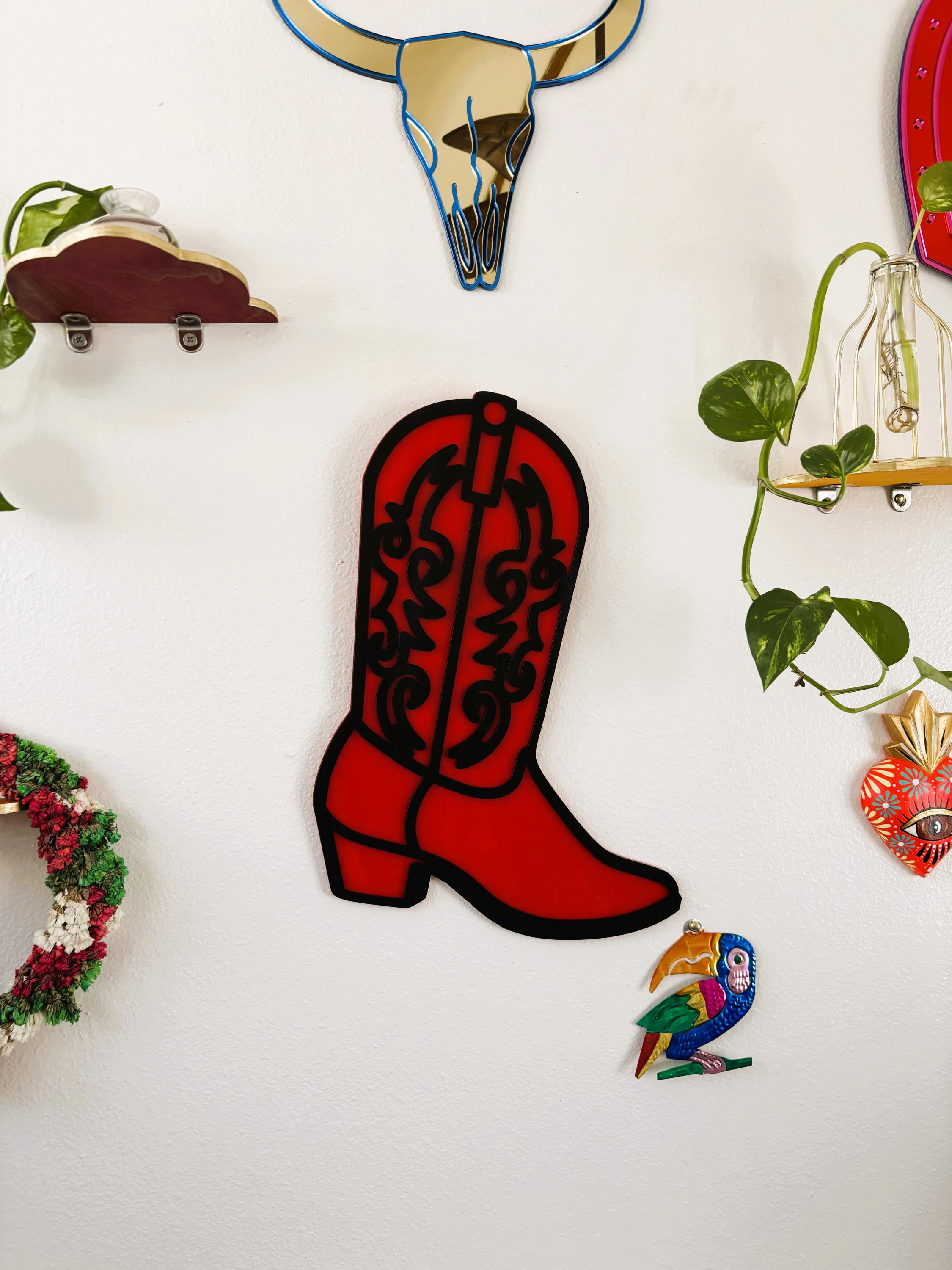 Decorative elements including a red cowboy boot, bull skull, wreath, and bird on a white wall.