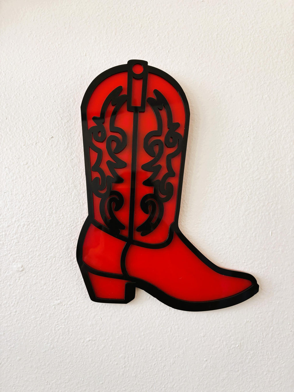 Red cowboy boot with black patterns on a white background
