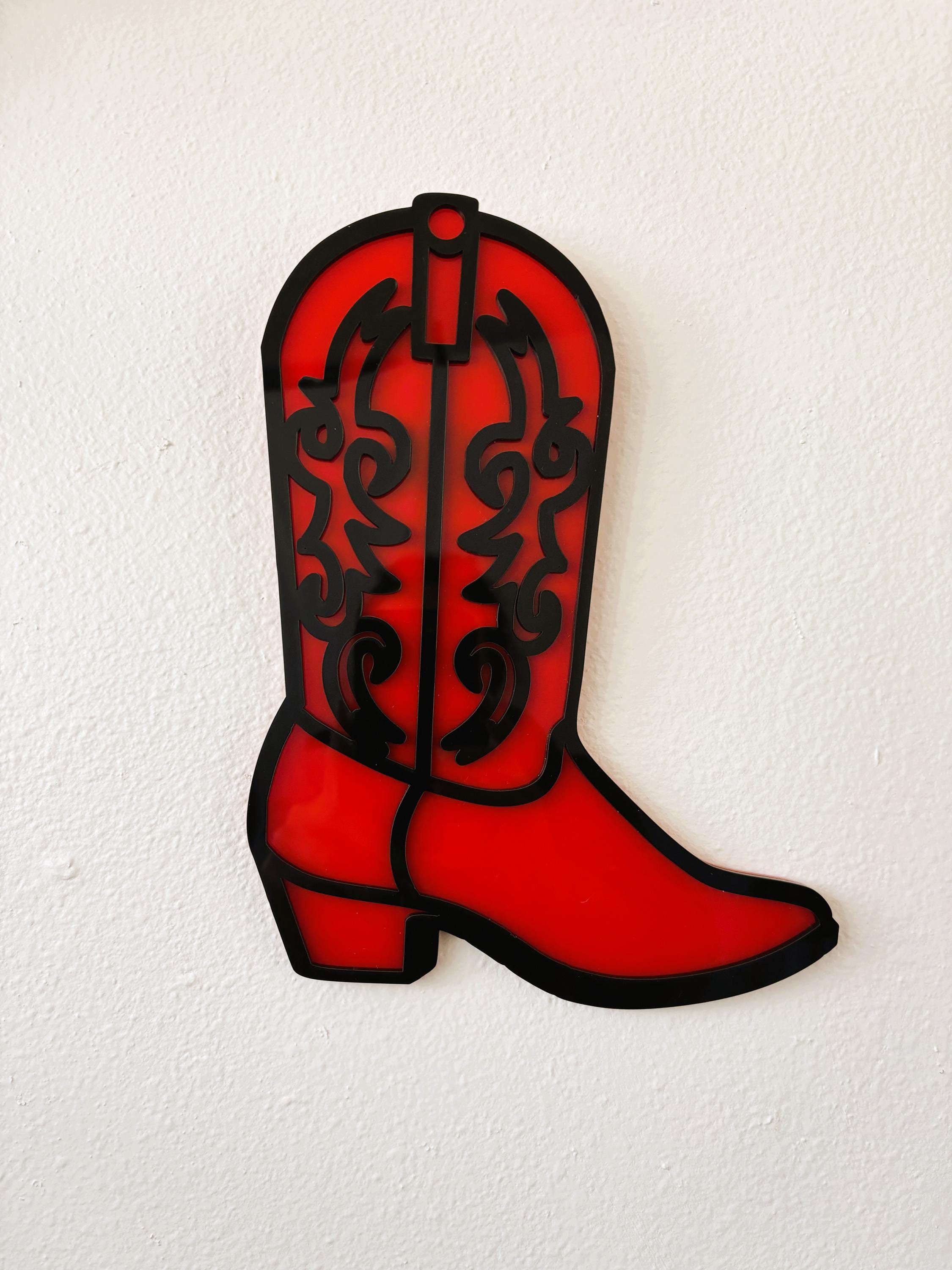 Red cowboy boot with black patterns on a white background