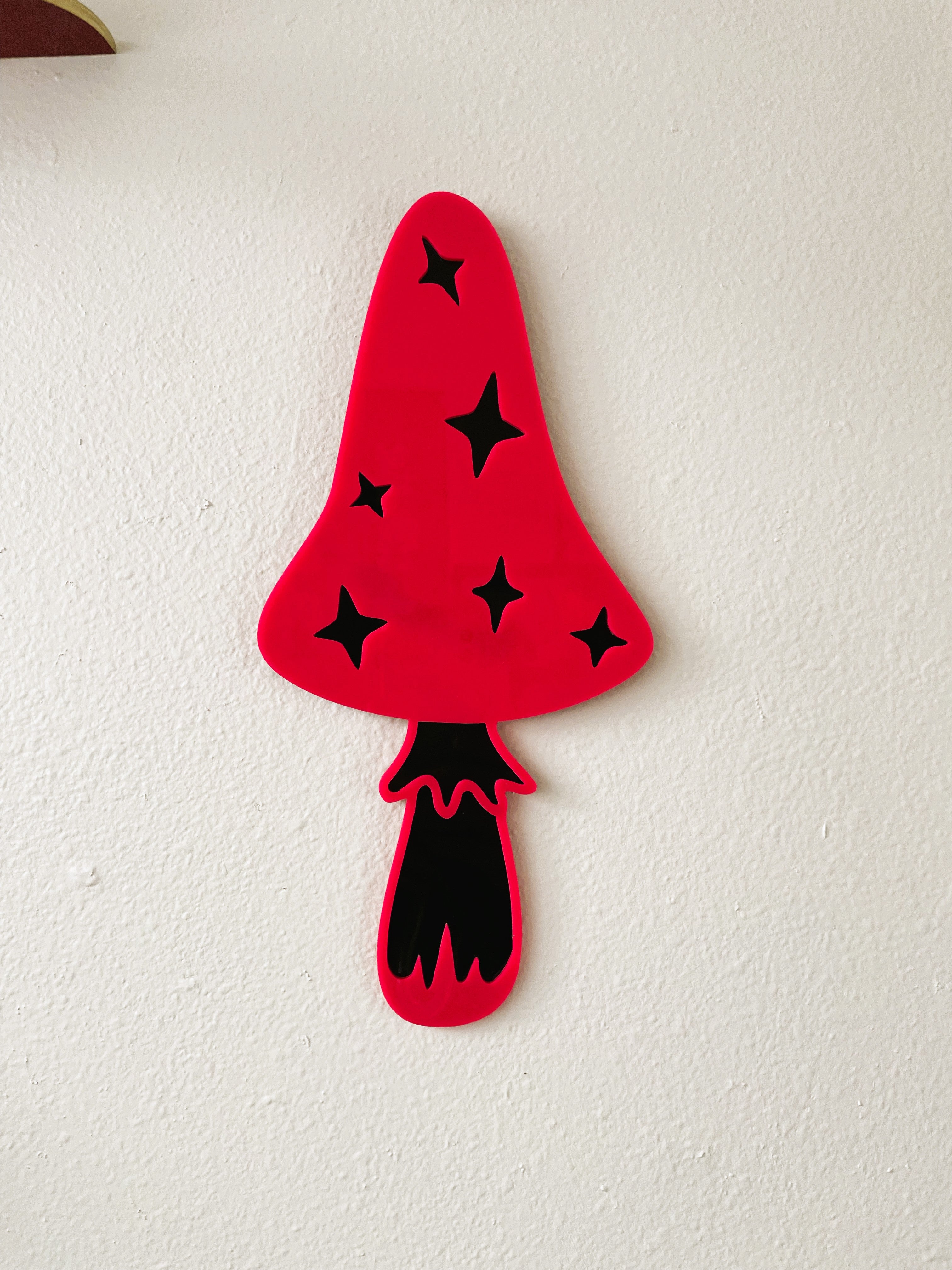 Red mushroom-shaped object with black star patterns on a white background