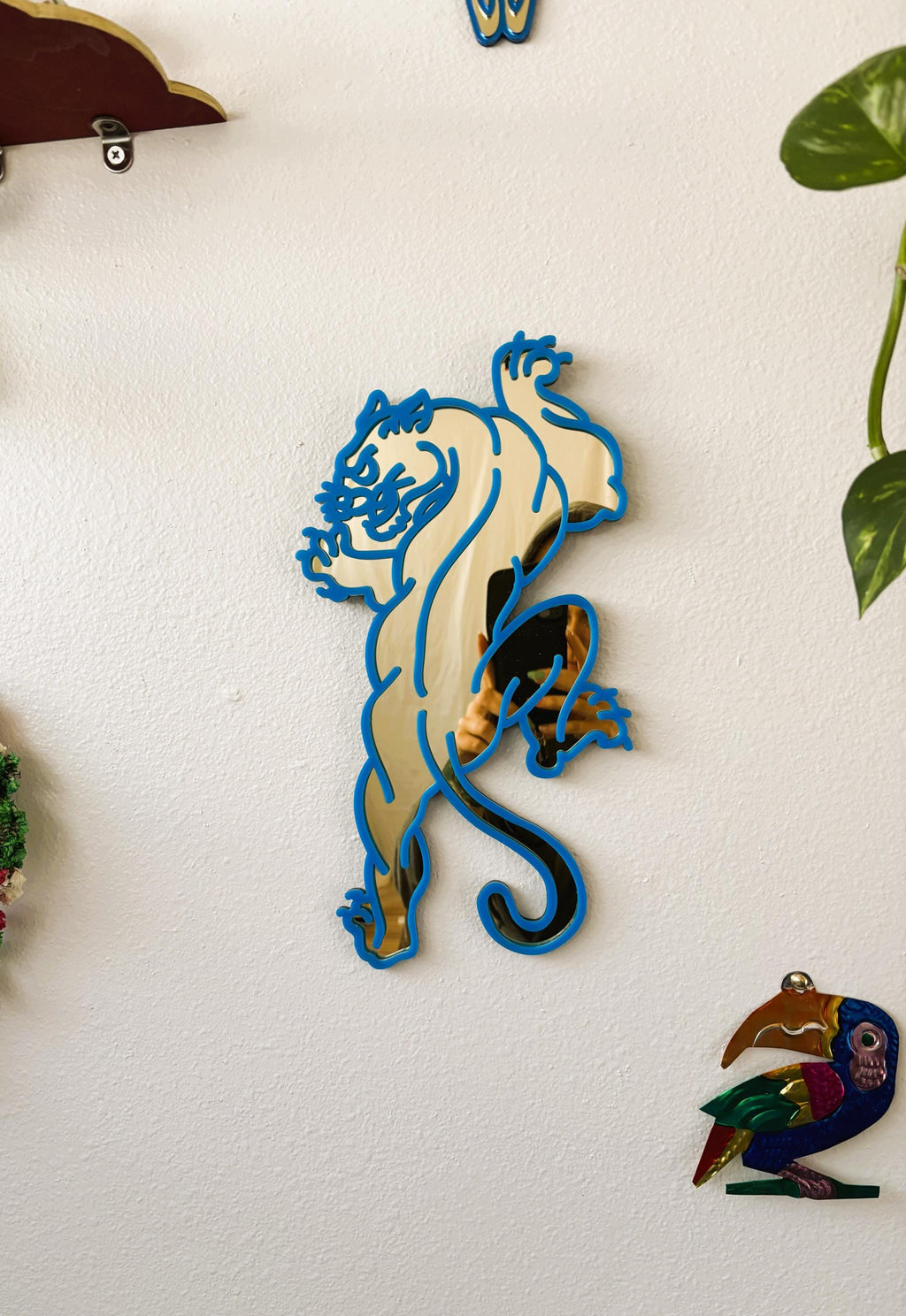 Decorative wall art of a stylized animal on a white wall.