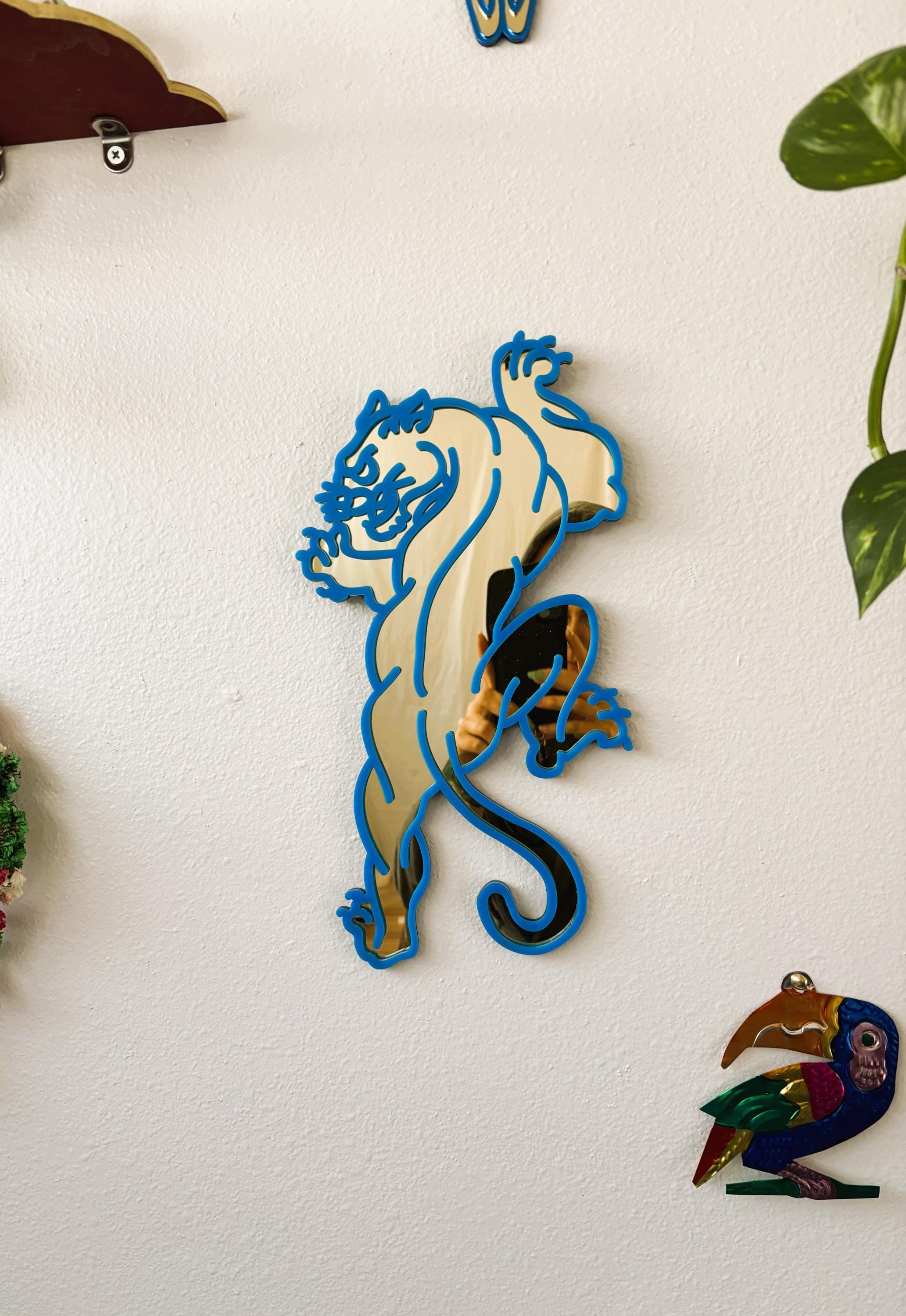 Decorative wall art of a stylized animal on a white wall.