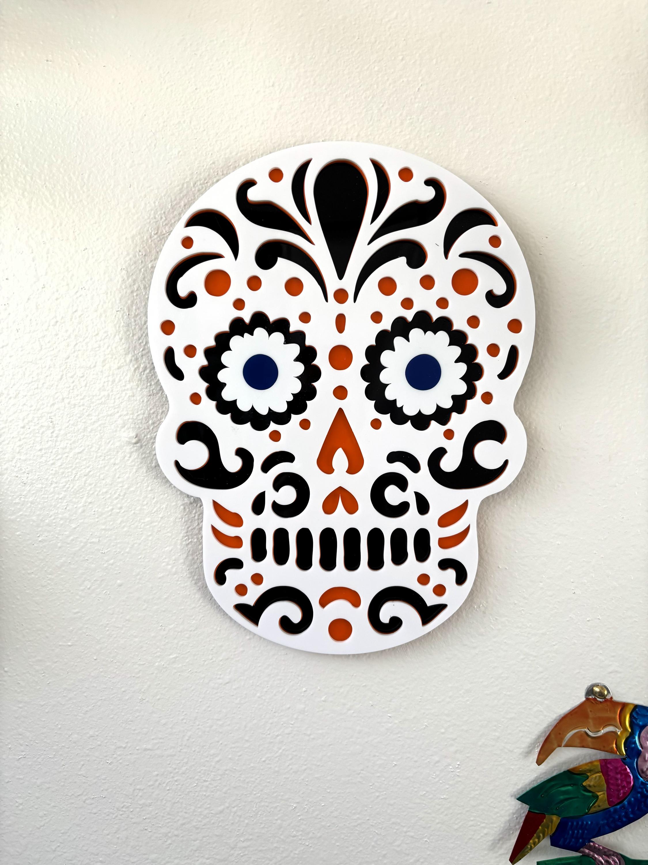 Decorative skull with colorful patterns on a white wall
