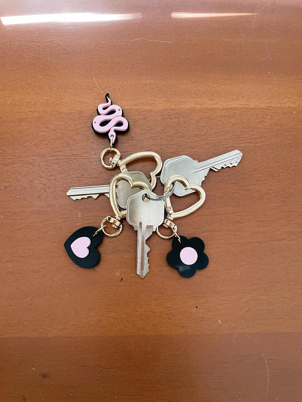 Keychain with keys and floral charms on a wooden surface